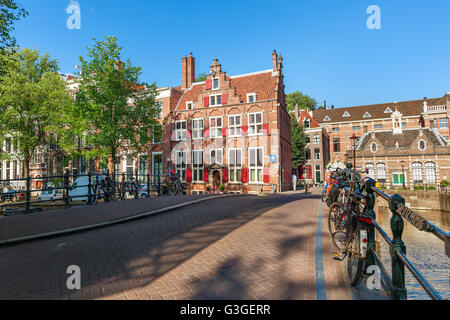 Bicycles on small bridge over canal and typical architecture on background in Amsterdam, Netherlands. Stock Photo