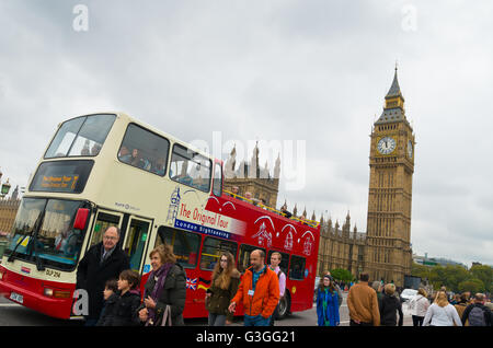 LONDON - OCTOBER 19, 2015: Sightseeing double-decker bus with unknown tourists in front of the Big Ben in London Stock Photo