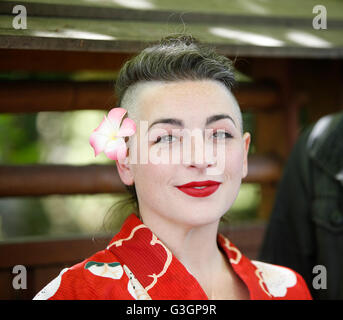 Cosplay Woman In Pink Kimono With Fists Near Face And Winking At Camera 