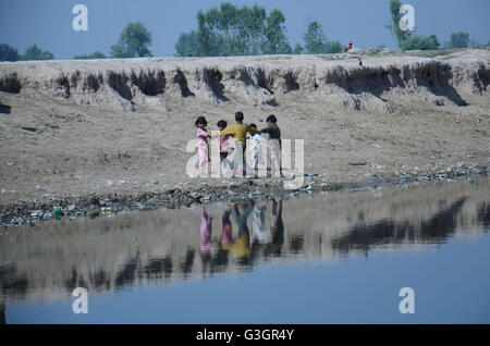 Lahore, Pakistan. 25th Apr, 2016. Pakistani children playing bank of dirty pond water near their slum home on the eve of world malaria day in Lahore. World Malaria Day (WMD) is an international observance commemorated every year and recognizes global efforts to control malaria. Globally, 3.3 billion people in 106 countries are at risk of malaria. In 2012, malaria caused an estimated 627,000 deaths, mostly among African children. Asia, Latin America, and to a lesser extent the Middle East and parts of Europe are also affected. © Rana Sajid Hussain/Pacific Press/Alamy Live News Stock Photo