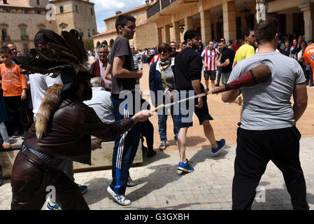 Almazán, Spain. 17th May, 2016. A man pictured wearing a hat decorated with vulture feathers and a tail of fox, representing an invincible shepherd that protects flocks of sheep from wolves, hits a man during the celebration of ‘El Zarrón' in Almazán. © Jorge Sanz/Pacific Press/Alamy Live News Stock Photo