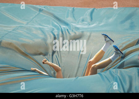 Pole vault athlete falls onto the crash mat during Stock Photo