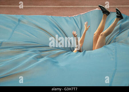 Pole vault athlete falls onto the crash mat during Stock Photo