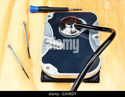 Stethoscope on the hard disk drive on a wooden table Stock Photo