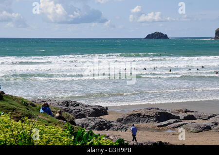 Cornwall - view over Polzeath beach - incoming tide - rocks and sand - white capped waves - blue sea and sky Stock Photo