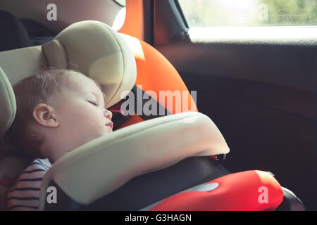 Baby sleeping in car safety seat while traveling Stock Photo
