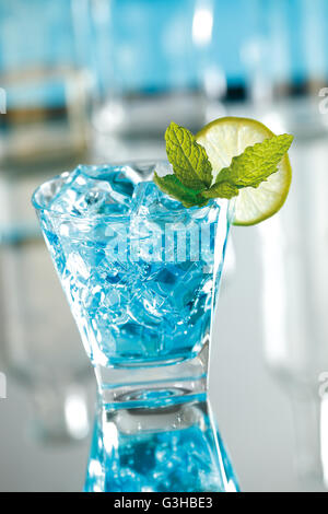 Blue mojito cocktail made with sugar, lime juice, mint leaves, soda, white rum and blue curacao. Stock Photo