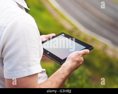 Man with digital tablet outdoors, close up Stock Photo