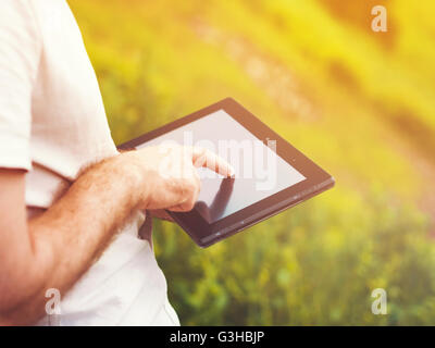 Man with digital tablet outdoors, close up Stock Photo