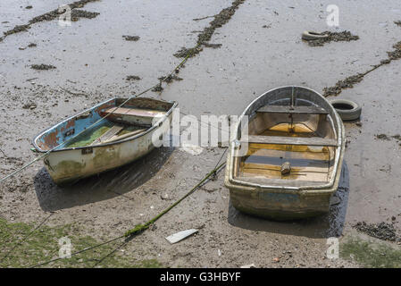 Beached two old rowing boats as a visual metaphor for 'washed up', beached, rescue, run aground, rescue plan, forgotten hulk, going down with the ship Stock Photo