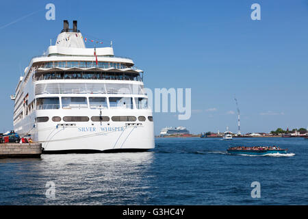 A canal cruise boat passing the MS Silver Whisper cruise liner moored at Toldboden in Copenhagen Harbour, Denmark. Stock Photo