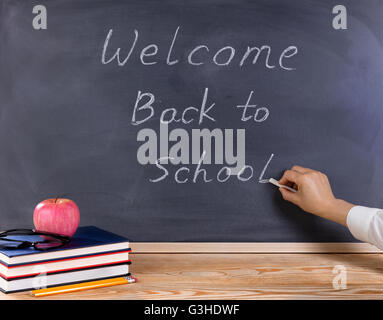 Student desktop and erased black chalkboard with welcome back to school ...