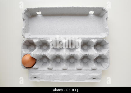 Eggs in packaging, missing eggs, one egg left, lonely alone concept Stock Photo