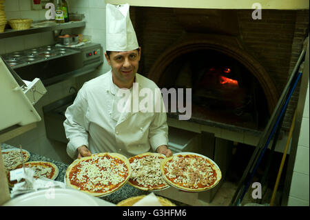 Chef preparing pizzas in a Restaurant  before cooking in a traditional pizza oven, Rome, Italy Stock Photo