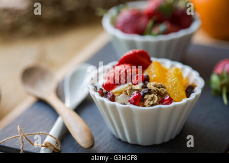 Granola with Orange, Strawberry, Cacao nibs and Pomegranate on yogurt Stock Photo