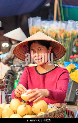 Hanoi, Vietnam: February 21, 2016: Womand selling fruits in a street market of Hoàn Kiếm, the old quarter of Hanoi Stock Photo