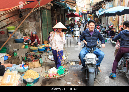 Hanoi, Vietnam: February 21, 2016: Womand selling fruits in a street market of Hoàn Kiếm, the old quarter of Hanoi Stock Photo