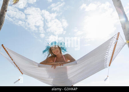 Portrait of young woman lying on hammock at Miami beach, Florida, USA Stock Photo