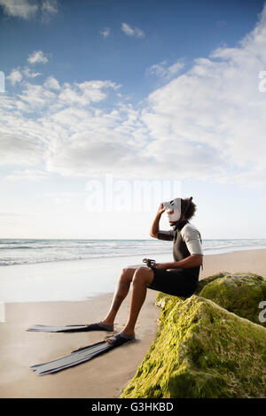 Diver sitting on rock, Palm Beach, Florida, USA Stock Photo