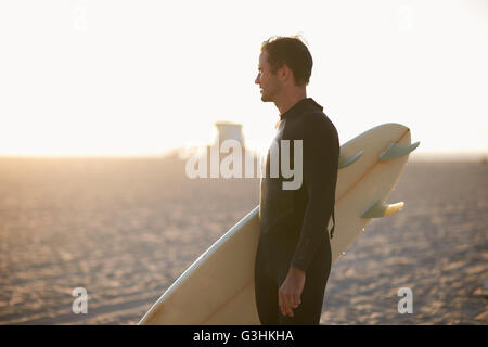 Male surfer with surfboard looking out from Venice Beach, California, USA Stock Photo