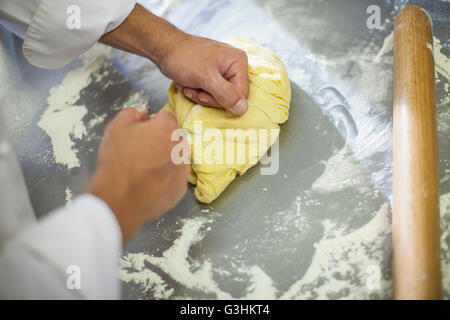 Chef kneading dough on table Stock Photo