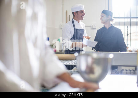 Chefs chatting in kitchen Stock Photo