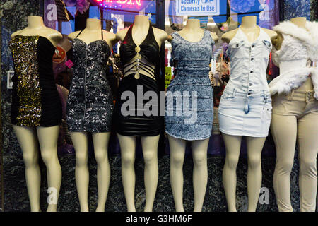 Row of six female dummies on sidewalk wearing mini dresses Stock Photo