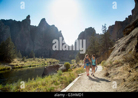 Hikers hiking along path by river Stock Photo