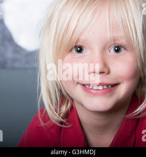 Close up portrait of blonde haired boy looking at camera smiling Stock Photo