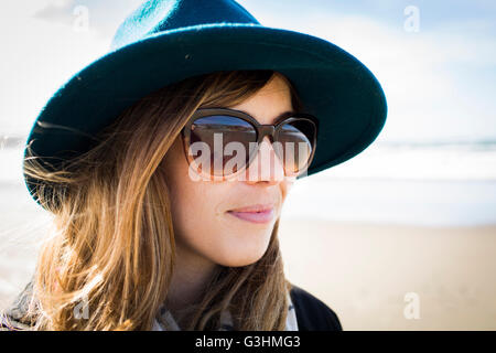 Portrait of stylish woman wearing felt hat and sunglasses, Dillon Beach, California, USA Stock Photo