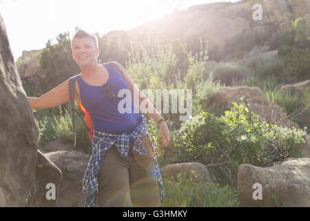 Woman hiker leaning against rock smiling Stock Photo