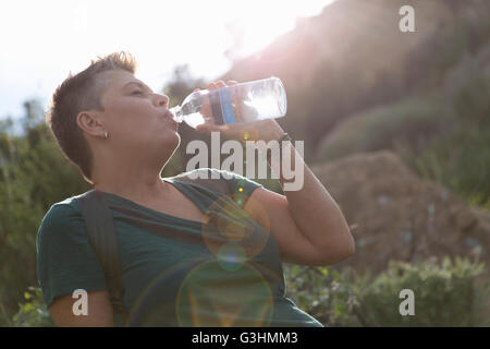 woman drinking water from plastic cup, isolated on a white