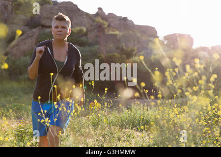 Woman jogging in wildflower meadow Stock Photo