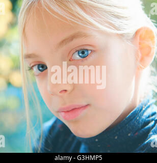 Close up portrait of blond blue eyed girl in garden Stock Photo