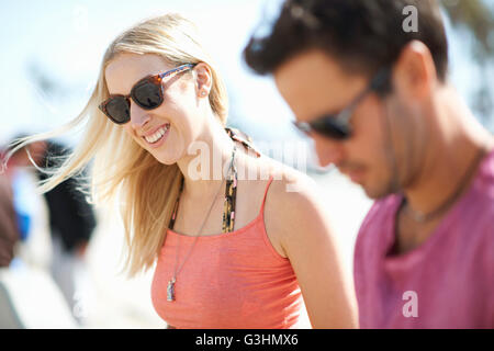 Couple outdoors, wearing sunglasses, smiling, focus on young woman Stock Photo