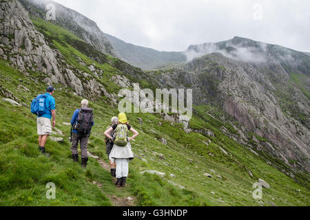 Hikers hiking up from Cwm Idwal approaching Seniors Ridge below Glyder Fawr in mountains of Snowdonia National Park. Ogwen Wales UK Stock Photo