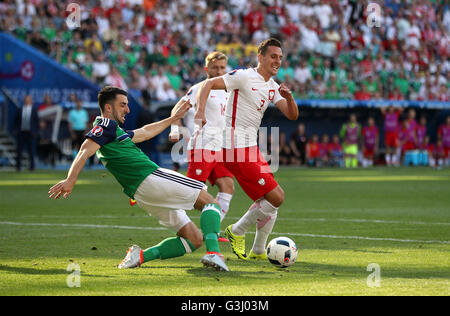 Northern Ireland's Conor McLaughlin (left) and Poland's Arkadiusz Milik battle for the ball during the UEFA Euro 2016, Group C match at the Stade de Nice, Nice. Stock Photo