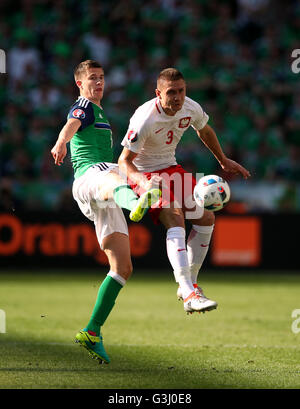 Northern Ireland's Paddy McNair (left) and Poland's Artur Jedrzejczyk battle for the ball during the UEFA Euro 2016, Group C match at the Stade de Nice, Nice. Stock Photo