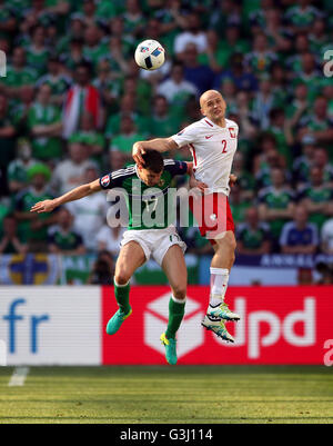 Northern Ireland's Paddy McNair (left) and Poland's Michal Pazdan battle for the ball in the air during the UEFA Euro 2016, Group C match at the Stade de Nice, Nice. Stock Photo
