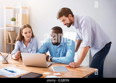 Positive smiling colleagues working on the project Stock Photo