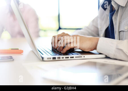 Young man working with laptop, man hands on notebook computer, business person at workplace Stock Photo