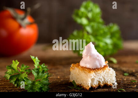 Roe salad appetizer with bread and herbs over wooden background