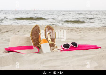 Accessories for vacation on sand at beach, sun protection on summer time, sunglasses, straw hat, sun lotion, sandals Stock Photo