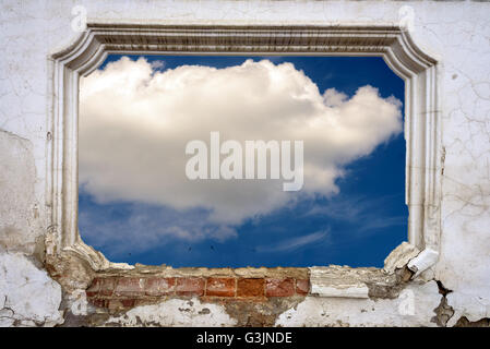 Recessed architectural detail of a grunge window style brickwork on a white wall with crumbling paintwork and cracked plaster Stock Photo