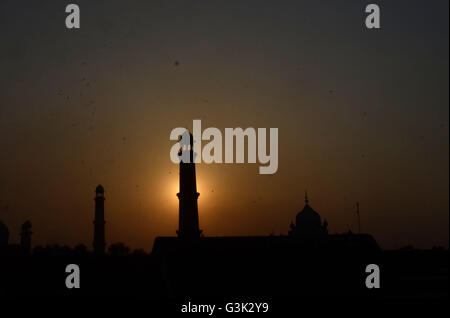 Lahore, Pakistan. 11th Apr, 2016. An attractive significant view of the sunset through historical Badshahi Mosque over the skies in Lahore. Badshahi mosque is one of the few significant architectural monuments built during Emperor Aurangzeb's long rule from 1658 to 1707. It is presently the fifth largest mosque in the world and was indisputably the largest mosque in the world from 1673 to 1986 when the Faisal Mosque was constructed in Islamabad. © Rana Sajid Hussain/Pacific Press/Alamy Live News Stock Photo