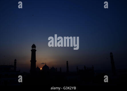 Lahore, Pakistan. 11th Apr, 2016. An attractive significant view of the sunset through historical Badshahi Mosque over the skies in Lahore. Badshahi mosque is one of the few significant architectural monuments built during Emperor Aurangzeb's long rule from 1658 to 1707. It is presently the fifth largest mosque in the world and was indisputably the largest mosque in the world from 1673 to 1986 when the Faisal Mosque was constructed in Islamabad. © Rana Sajid Hussain/Pacific Press/Alamy Live News Stock Photo