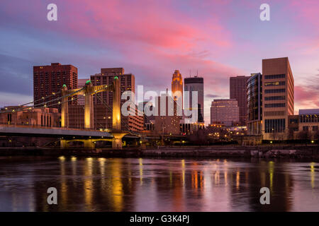 Colorful sunset over Minneapolis skyline with the Mississippi River and Hennepin Avenue bridge in the foreground. The Mississipp Stock Photo