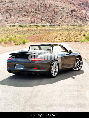 Porsche 911 Carrera S on a desert mountain road Stock Photo