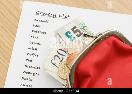 Shopping list for groceries with sterling money cash GBP in a purse from above. England, UK, Britain Stock Photo