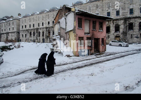 Two Muslim Women walk in the snow in the Süleymaniye district of Istanbul Stock Photo